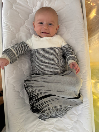 baby enjoying arms up in safe sleep sack