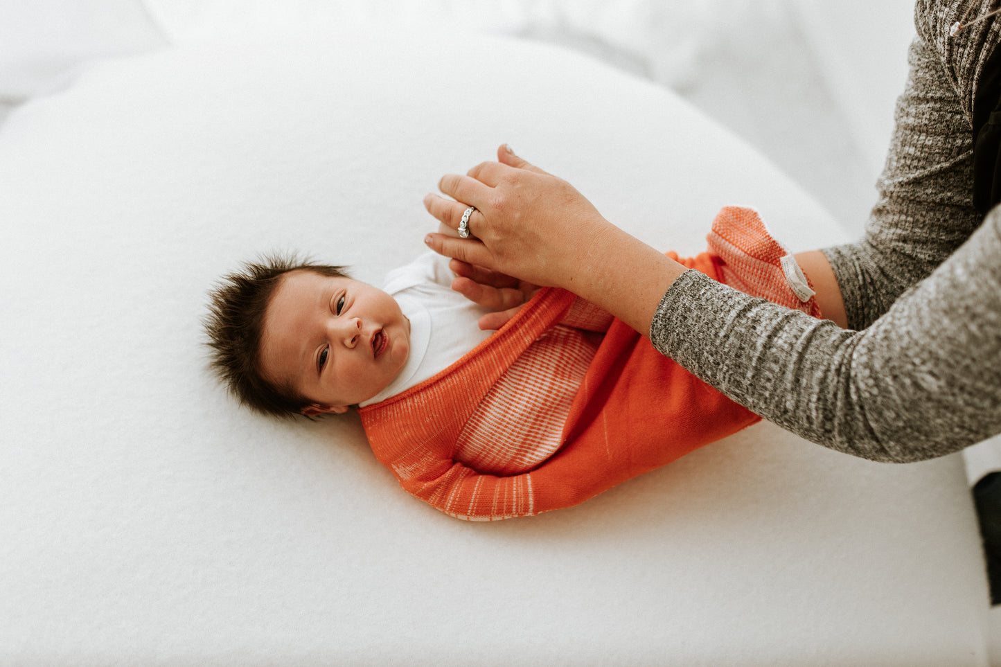 A happy baby in a swaddle.