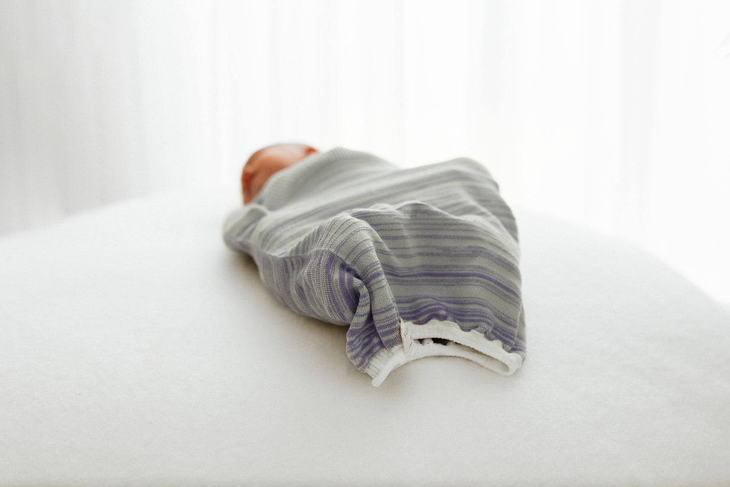 A baby resting in a special swaddle made for babies with hip dysplasia.