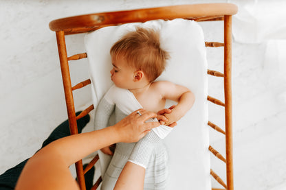 A mother putting her baby's transition swaddle on.