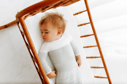 A toddler sleeping in a knit transition swaddle.