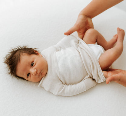 Changing a diaper with the Swaddelini diaper opening.