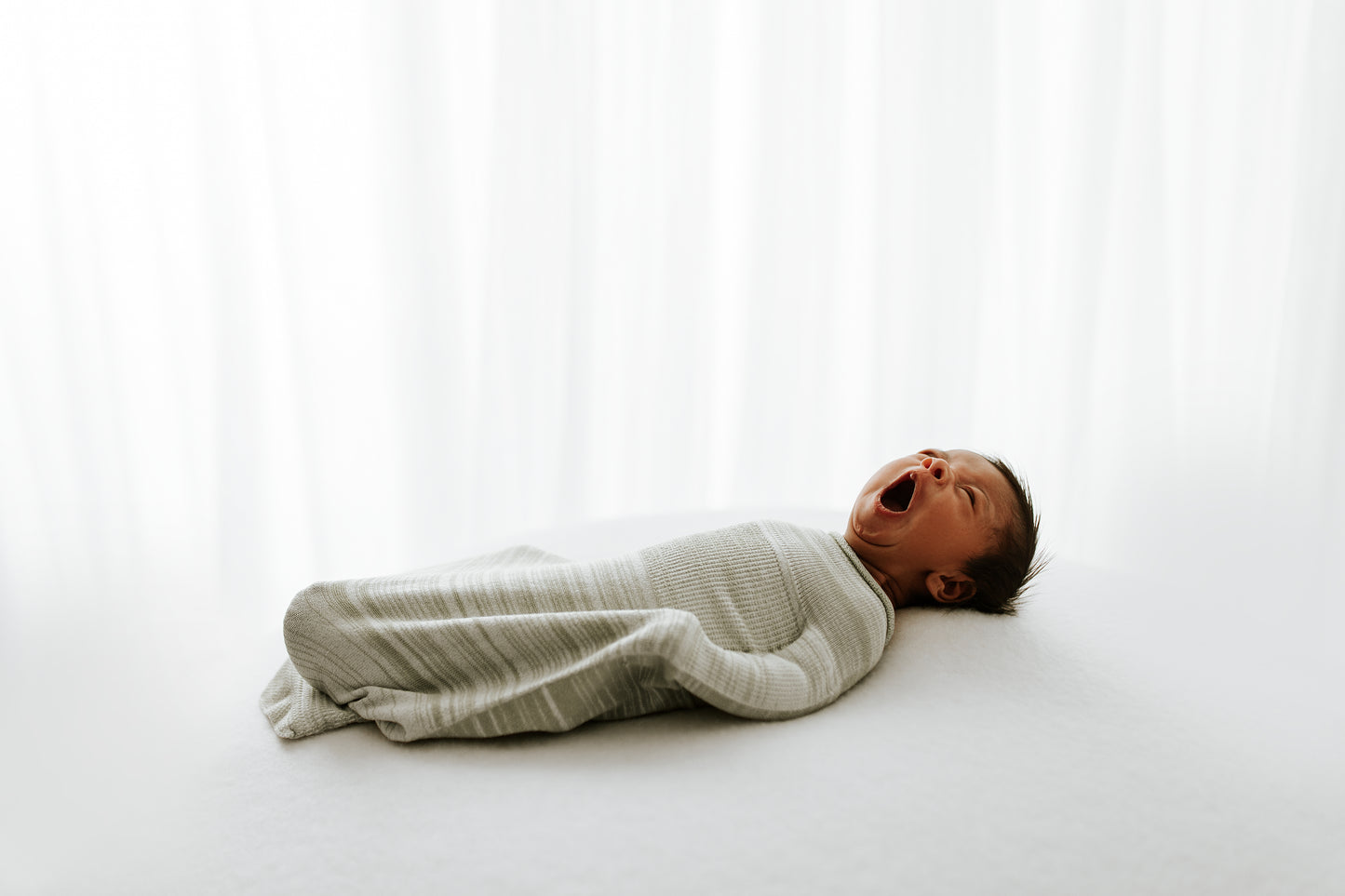 A tired baby in a swaddle.