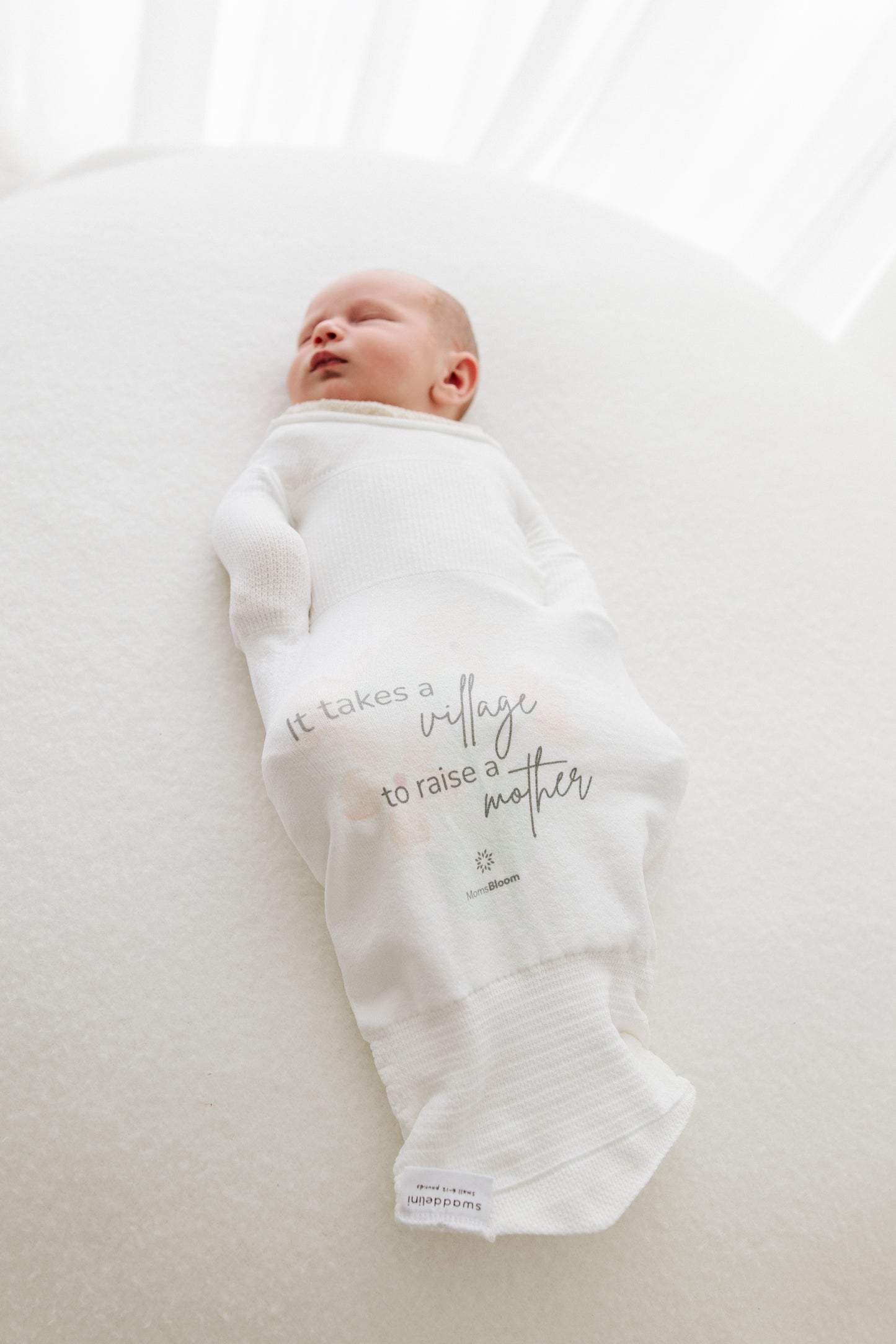 baby sleeping in safe sleepsack with good message to new mothers