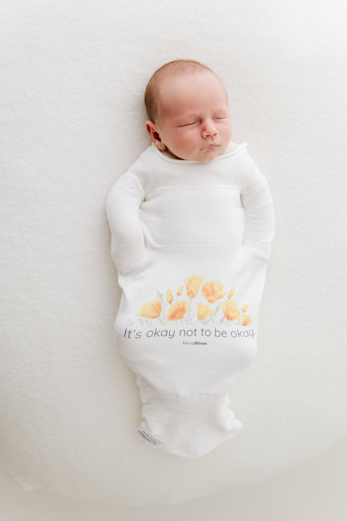 newborn sleeping safely in Swaddelini 3D knit swaddle