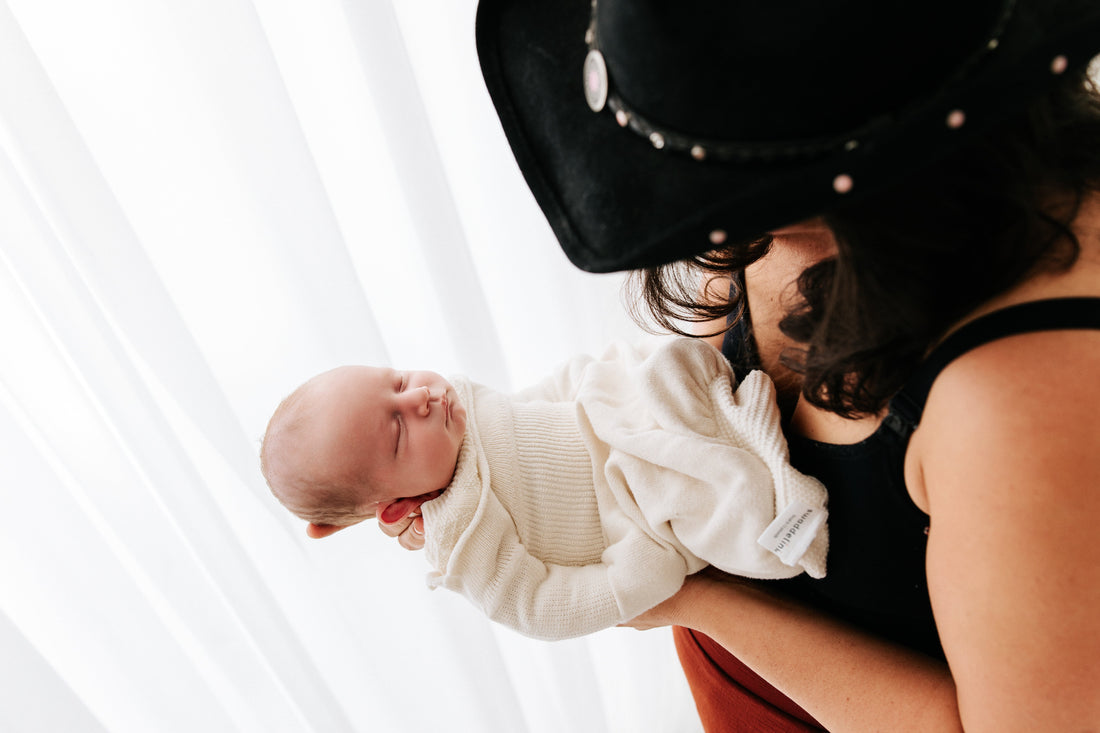 Best Black Friday Cyber monday deal must buyholding a newborn baby in an organic cotton swaddle