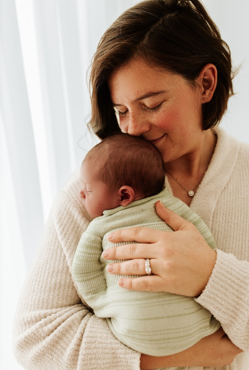 Mother caring for her baby sleeping in a sleep sack.