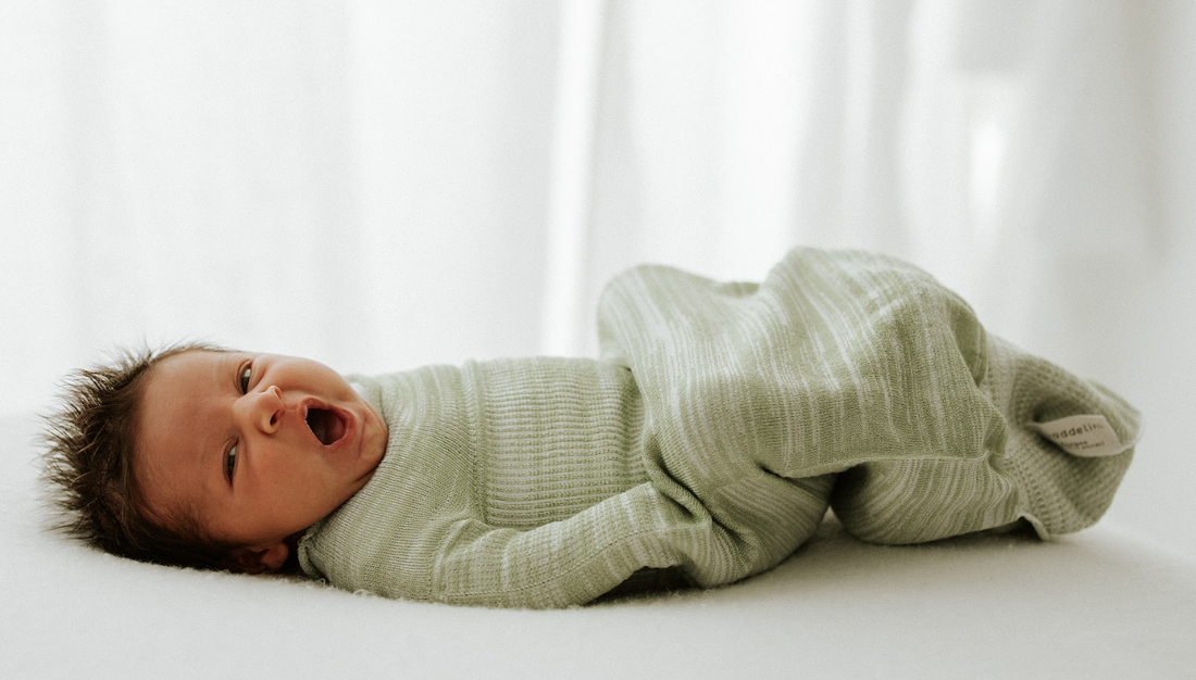 a baby lying in a swaddle