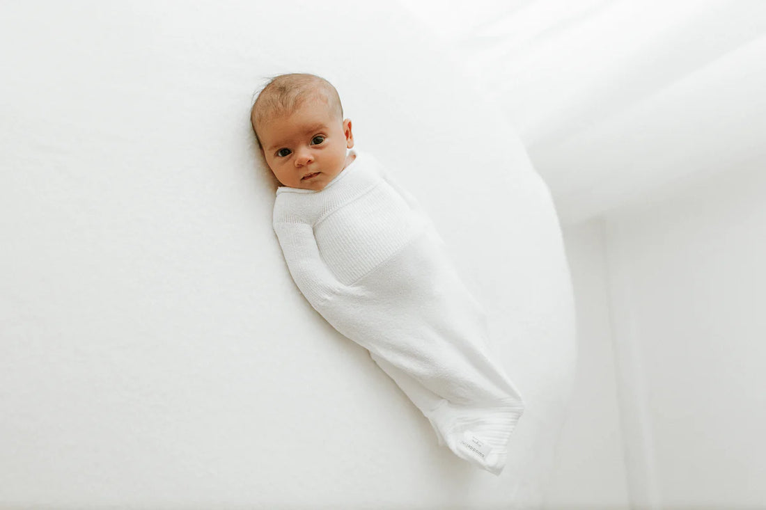 Baby lying in swaddle sleep sack