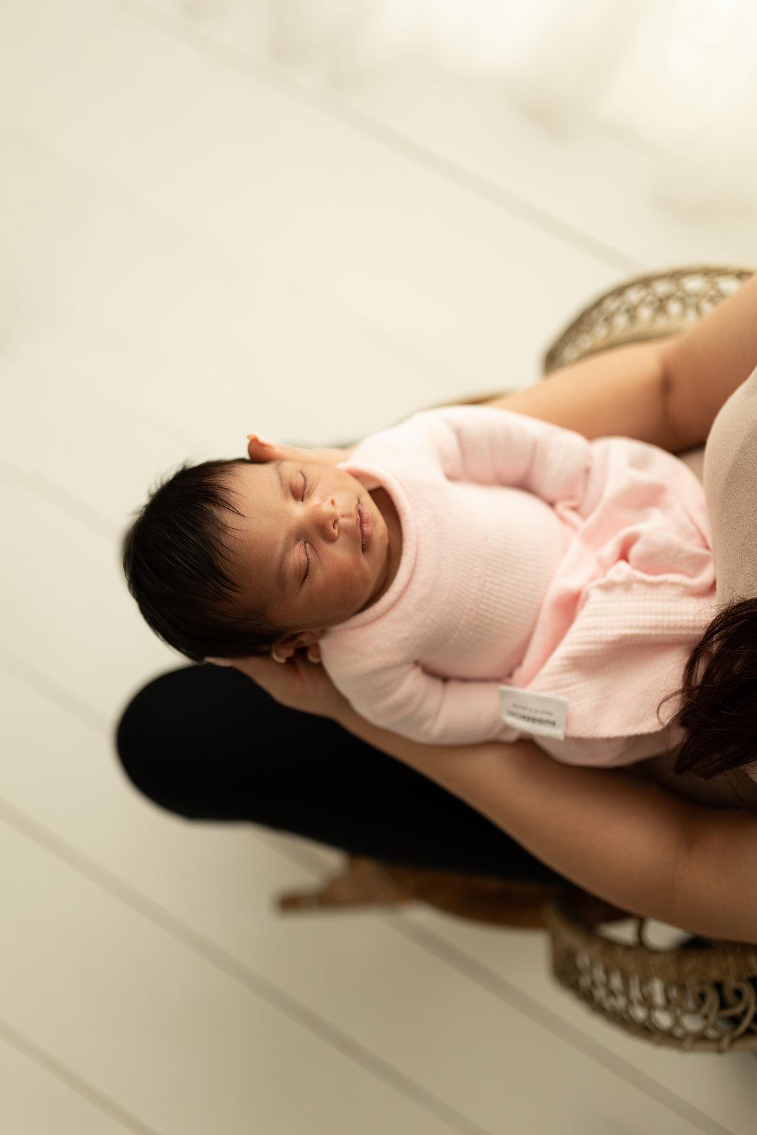 infant in a pink swaddle sleep sack