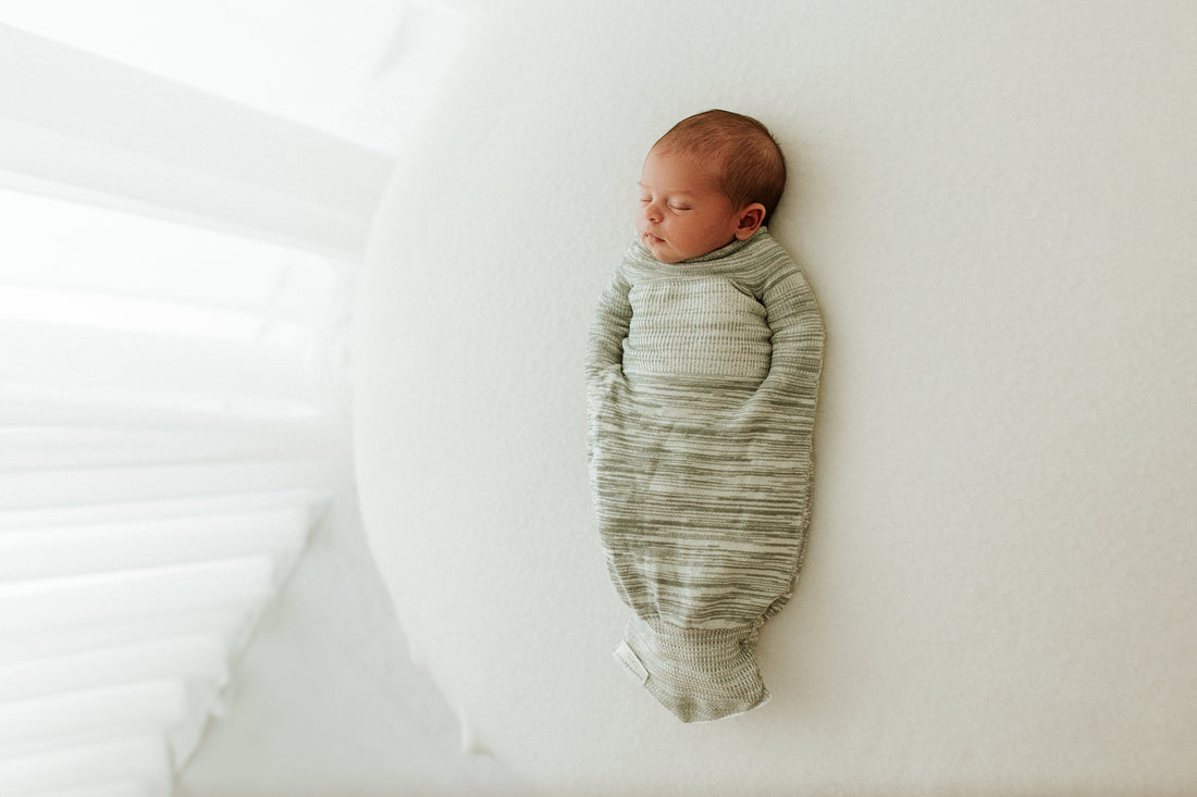 a baby sleeping in a swaddle