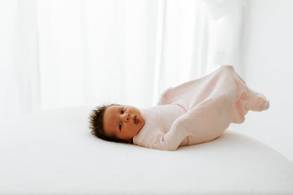 A baby being active in an accommodating sleep swaddle.