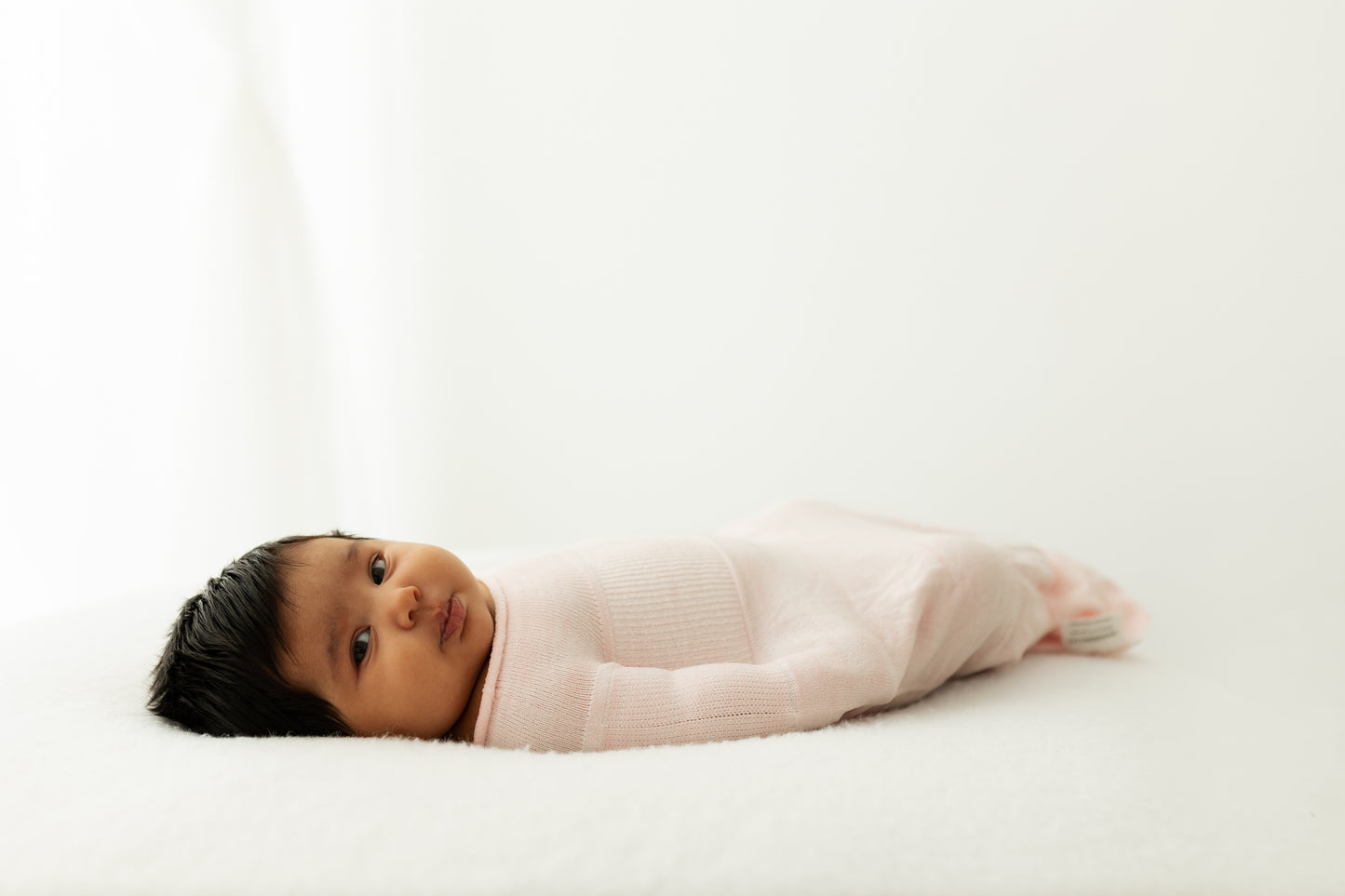 A baby resting in an infant sleep sack.