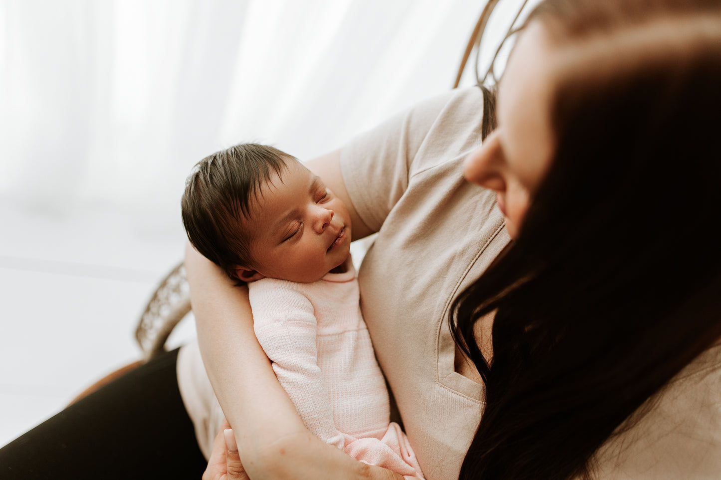 A mother calming her baby in a sleep sack.