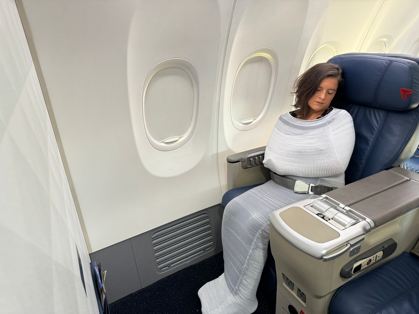 Adult relaxing inside Swaddelini Body Compression Sock on a plane with flight anxiety